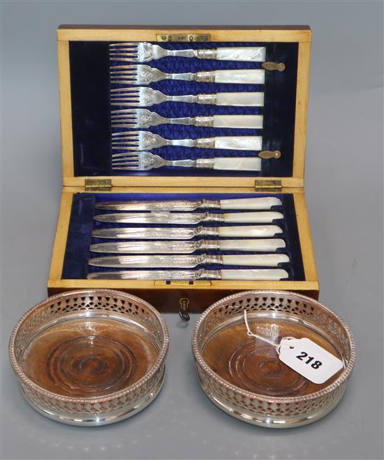 A cased set of mother of pearl handled fruit eaters and two coasters